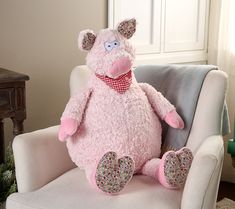 a pink pig stuffed animal sitting on top of a chair