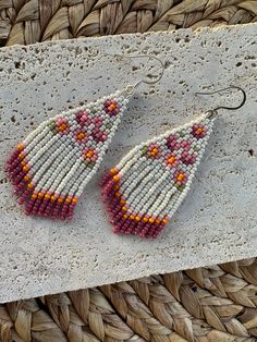 a pair of beaded earrings sitting on top of a table