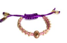 Beaded macrame bracelet with adjustable clasp. This is a stackable bracelet, you can wear it with other type of bracelets, the more the merrier, it will give that boho-chic style, with a sliding clasp. This beauty was made using the macramé technique. It was made with purple nylon cord and pink/salmon S-Lon cord, using the flat knot with golden tone (6/0) metal beads incorporated to the sides of the wrap; the focal point is a golden tone metallic bead. The result is an elegant, one-of a kind bra Bohemian Pink Beaded Bracelets With Adjustable Cord, Pink Bohemian Beaded Bracelets With Adjustable Cord, Pink Bohemian Braided Bracelet With Sliding Knot, Bohemian Pink Braided Bracelet With Sliding Knot, Purple Sliding Knot Bracelet For The Beach, Purple Bracelet With Sliding Knot For Beach, Handmade Adjustable Purple Bracelets, Handmade Adjustable Purple Bracelet, Adjustable Purple Braided Bracelets For Festival