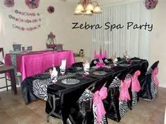 a zebra themed party with pink and black decorations on the wall, table cloths and chairs