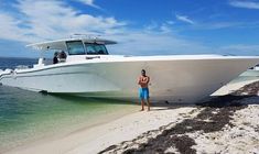 a man standing on the beach next to a boat