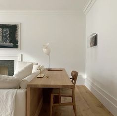 a white couch sitting next to a wooden table on top of a hard wood floor