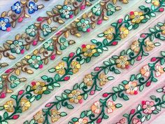 several pieces of embroidered fabric with flowers and leaves on them, all in different colors