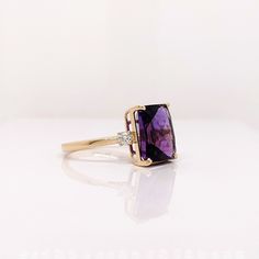 This cocktail ring features a stunning vibrant deep purple amethyst in 14K gold with diamond accents. This statement ring makes for a stunning accessory to any look! A fancy ring design perfect for an eye-catching engagement or anniversary. This ring also makes a beautiful February birthstone ring for your loved ones. February Birthstone Ring, Designer Silver Jewellery, Purple Amethyst Ring, Fancy Rings, Jewelry Showcases, February Birthstone, Radiant Cut, Royal Purple, February Birth Stone