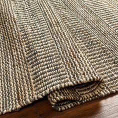 a close up view of a rug on the floor with wood floors in the background