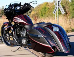 a black and red motorcycle parked on the side of the road next to a street sign