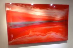 an orange and red painting hanging on the wall