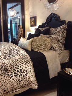 a leopard print comforter and pillows on a bed