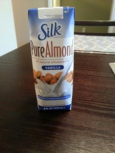 a bag of pure almonds sitting on top of a wooden table