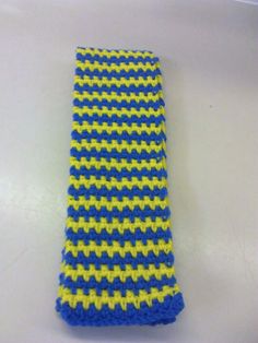 a blue and yellow knitted tie laying on a table