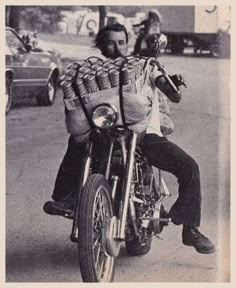 a man riding on the back of a motorcycle down a street