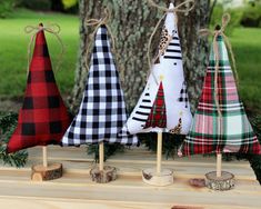 three small christmas trees are sitting on top of a wooden table in front of a tree