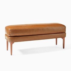 a brown leather bench sitting on top of a wooden frame