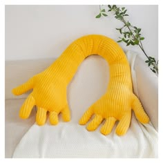 two yellow gloves sitting on top of a white couch