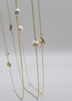 Named after a spin on the lovely Marigold flower, this pearl necklace symbolizes divinity as well as the beauty of patience on your journey to growth/alignment. She adds a simple-yet-striking touch of elegance and grace, and is very versatile for styling! Made with high-quality 14K Gold Filled materials, the Merrigold necklace is both water/tarnish-resistant, so you can swim all day and night under the sun and moon. NECKLACE DETAILS: 14K Gold-Filled Chain Freshwater Pearl Unique 14K Gold-Filled GEO Tag MEASUREMENTS: 16.5" Necklace Note: Many GEOLOVERS pieces are uniquely handmade. Each piece may vary slightly as a result, including the shapes of natural pearls. Elegant Gold Single Strand Pearl Necklace, Gold Spiritual Necklace With Pearl Drop, Gold Spiritual Pearl Necklace, Spiritual Gold Necklaces With Pearl Drop, Spiritual Gold Necklace With Pearl Drop, Spiritual Gold Pearl Necklace With Pearl Charm, Gold Pearl Necklace With Spiritual Charm, Spiritual Gold Pearl Drop Necklace, Spiritual Gold Pearl Necklace With Charm