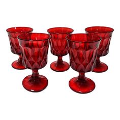 six red glass goblets sitting next to each other