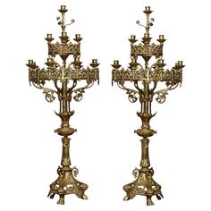 two golden candelabras with candlesticks on each side and an ornate design