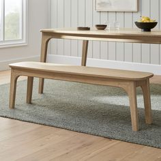 a wooden bench sitting on top of a carpeted floor next to a bowl of fruit