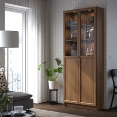 a living room scene with focus on the glass front cabinet and chair in the foreground