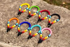 six multicolored lanyards are sitting on a rock