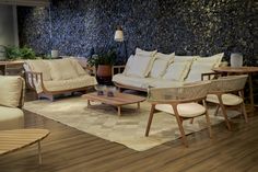 a living room filled with lots of furniture next to a wall covered in blue stones