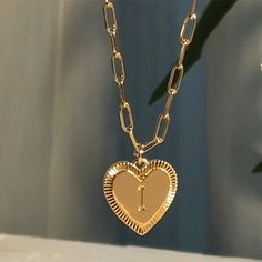 Personalize your wardrobe with the YourLetter Heart Necklace. This stylish piece of jewelry features an elegant gold-colored heart design, and allows you to choose the letter of your choice, making it a unique and thoughtful gift. Express yourself and stay stylish with this personalized necklace. Letter Name Necklace, Initial Jewelry Necklace, Initial Heart Necklace, Gold Initial Pendant, Diy Pendant Necklace, Choker Gold, Gem Earrings, Letter Pendant Necklace, Pendant Choker