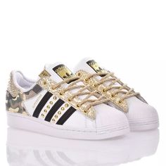 Adidas Superstar Lady Camo is the custom women's sneaker, the back of the shoe is covered in denim fabric with military print while the back and laces are in python print leather in cream and gold, all finished with gold round studs between the stripes and perfectly matched cream rope laces with gold laminations. You will also be provided with its original white laces. | Mimanera Women's Adidas Superstar Gold | SS24 Gold Sneakers With Vulcanized Sole For Streetwear, Gold Leather Custom Sneakers For Streetwear, Gold Leather Sneakers For Streetwear, Gold Leather Sneakers With Laces, Gold Leather Sneakers, Luxury Gold Lace-up Custom Sneakers, Gold Lace-up Sneakers, Adidas Superstar Gold, Adidas Superstar Women