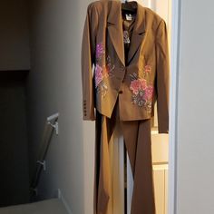 2 Piece Brown Suit With Flower Detail. Lined Jacket. Tailored Embroidered Outerwear For Spring, Tailored Floral Embroidered Blazer For Spring, Tailored Embellished Spring Outerwear, Fitted Floral Embroidery Blazer For Work, Elegant Embroidered Spring Blazer, Fitted Floral Embroidered Outerwear For Work, Fitted Floral Embroidery Blazer For Spring, Spring Tailored Blazer With Embroidery, Spring Embellished Fitted Blazer