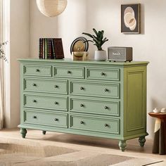 a green dresser with many drawers in a room