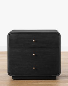 a black dresser with two drawers on top of it and a wooden floor in front of the