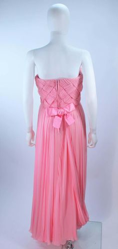 For Sale on 1stDibs - This Scaasi gown is composed of a pink chiffon. The bodice has a criss-cross design. The skirt features a drape style. There is a center back zipper closure Pre-draped Pink Silk Evening Dress, Fitted Gown With Sheer Bodice In Georgette, Fitted Georgette Gown With Sheer Bodice, Pink Fitted Chiffon Wedding Dress, Pink Fitted Chiffon Dress For Wedding, Fitted Pink Chiffon Dress For Wedding, Pink Gown With Boned Bodice For Gala, Formal Pre-draped Pink Gown, Pink Sleeveless Chiffon Wedding Dress