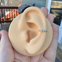 a person is holding an ear ring in their hand