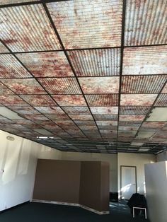 an empty room with some walls and ceilings covered in rusted metal sheet covering the ceiling