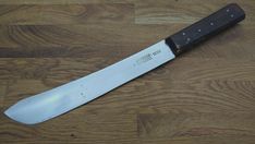 a large knife laying on top of a wooden floor