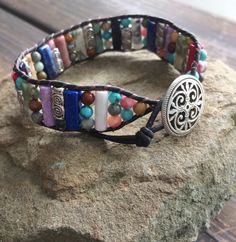 This multi color beaded bracelet for women is stunning and unique. This single wrap bracelet would compliment and outfit you want to wear it with. This bracelet would be a beautiful meaningful gift for your mother on Mother's Day. It will be a gift she can enjoy every day. This leather beaded bracelet is made with a variety of gemstone beads in various sizes and colors. Please choose the size you would like at check out. Beaded Wrap Bracelet For Gift, Adjustable Cuff Bracelet With Colorful Beads For Gifts, Adjustable Cuff Bracelet With Colorful Beads As Gift, Adjustable Hand-strung Cuff Bracelet Gift, Colorful Adjustable Spiritual Jewelry, Multicolor Beaded Wrap Bracelet As Gift, Multicolor Beaded Friendship Wrap Bracelet, Hand-strung Multicolor Bracelets For Friendship, Bohemian Cuff Bracelet With Hand Wrapped Round Beads