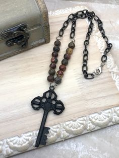 Unlock your unique style with this 21 inch skeleton key necklace! It effortlessly combines vintage vibes with a rustic key pendant and the beautiful addition of gemstone beads. This statement piece is sure to turn heads and add an eye-catching flair to any outfit. The black skeleton key pendant is 1.5 by 2.5 inches. Please select your bead type when ordering. Each necklace is sold separately. Skeleton Key Necklace, Red Creek Jasper, Boho Style Necklaces, Zebra Jasper, Skeleton Key, Key Necklace, Pink Zebra, Key Pendant, Jasper Beads