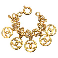 Vintage Chanel gold toned bracelet in clover links adorned with five CC charms. Absolutely a rare piece to add to your vintage collection. Length measures approximately 20 cm. Stamped 93P made in France. Comes with box. Condition: In excellent vintage condition with minimal signs of wear Chanel Bracelet, Character Board, Hats Accessories, Bracelet Vintage, Vintage Chanel, Arm Band, Link Bracelets, Chain Bracelet, Vintage Collection