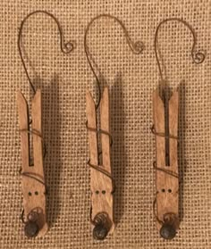 three pieces of wood with hooks attached to them on a burlock cloth background