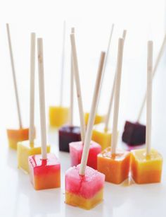 several popsicles with toothpicks sticking out of them on a white countertop