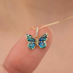 What do Butterflies symbolize? Dance Like the Butterfly Butterflies bring color and joy with them. They awaken a sense of lightness and joy. They symbolize purity, love, grace, lightness of being, dignity, good luck, hope, and unpredictability. This beautiful blue enamel butterfly necklace is a perfect gift for the holiday season, making it a thoughtful Christmas or New Year's gift that adds a touch of elegance and meaning. Our product is carefully crafted by applying genuine glass enamel on 14k Butterflies Symbolize, Gold Butterfly Necklace, Enamel Butterfly, Butterfly Necklace Gold, Solid Gold Necklace, Necklace Blue, Holiday Jewelry, Gold Butterfly, Butterfly Necklace