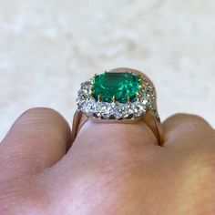 An impressive cluster ring that features a lively 4.55 carat natural Colombian emerald-cut emerald with a green saturation. Surrounding the center stone is a cluster of old European cut diamonds. This ring is crafted in platinum and 18k yellow gold.
The center emerald is GIA certified stating that it is a natural Colombian emerald weighing 4.55 carats and has minor oil treatment.
The total approximate weight of the diamonds is 1.50 carats.
This ring can be resized to any finger size at no extra Colombian Emerald Ring, European Cut Diamond Ring, Estate Diamond Jewelry, Columbian Emeralds, Gia Certificate, Emerald And Diamond Ring, Colombian Emeralds, Gemstone Engagement, 18k Yellow Gold Ring