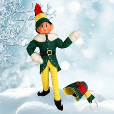 an elf is standing in the snow with his hat on and boots hanging from his feet