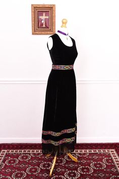 Made from silky black velvet, this mystical vintage 1960s maxi dress features colourful aztec style embroidered detailing around the waist and hem. It's sleeveless with a scoop neckline featuring long, black fringed hem and a zip closure at the back. Best fits size S. Bust: 35" Waist: 28" Hips: 40" Shoulders: 14" Length: 52" Mannequin measures 31" bust, 25" waist and 35" hips. Garment pinned to fit. In good vintage condition. There are some faint stitch marks around armholes along with other min Hippie Maxi Dress, Aztec Style, Aztec Fashion, Vintage Hippie, Black Fringe, Long Black, Dress Clothes For Women, Vintage 1960s, Velvet Fabric