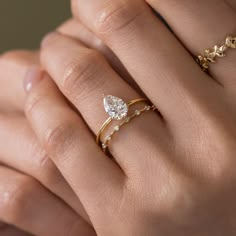 a woman's hand with two gold rings and one diamond ring on her finger