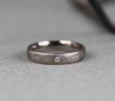 a close up of a wedding ring with a diamond on it's center piece