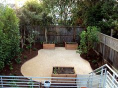 a small backyard garden with raised planters and gravel