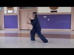 an older man is dancing in the middle of a room with purple walls and doors