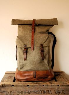 Swiss Army Backpack - Roll Top - from 1950s, made from canvas and leather.   In very good vintage < < < P R O D U C T  D E S C R I P T I O N > > > Perhaps the best military canvas rucksack of all time and certainly the most sought-after, this is the 1950's canvas and leather Swiss Army Backpack . The design was so successful it remained in use for decades even being re-made using a ballistic nylon material as seen in the Swiss Backpack from the 1980's. The Swiss Army Backpack has tough forged an Everyday Vintage Satchel Backpack, Everyday Vintage Bags With Leather Trim, Vintage Leather Backpack With Leather Patch For Adventure, Vintage Backpack With Leather Backing, Vintage Leather-backed Backpack, Retro Leather Backpack, Retro Canvas Backpack, Vintage Brown Canvas Backpack, Vintage Outdoor Bags With Waxed Finish