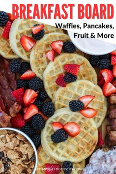 waffles, bacon, strawberries, and other breakfast foods are arranged on a platter