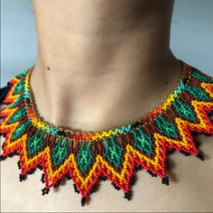 a woman wearing a multicolored beaded necklace on top of her chest,